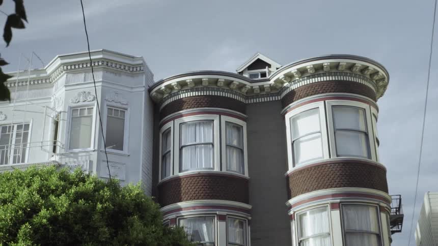 A row of houses are filmed from the street