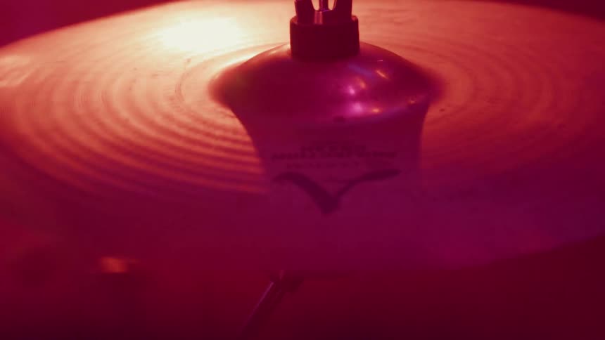 Drum cymbal vibrating as it gets hit with a drumstick