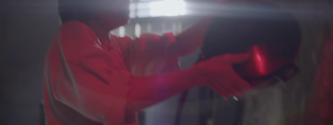 A woman is emptying out a pan of water under red lights