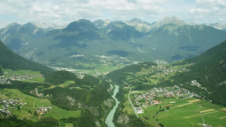 A river runs between mountains and villages