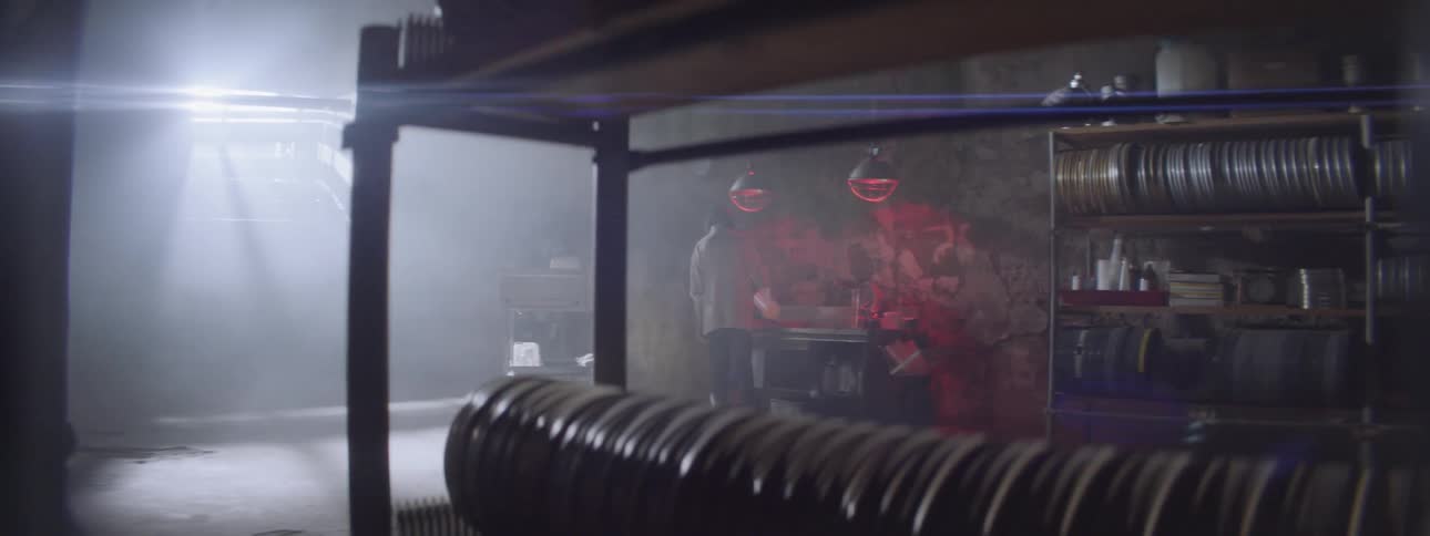 A woman is standing at a table with red lights above her head