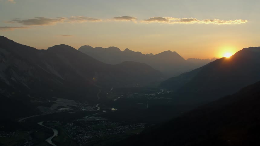 The sun is nearly set behind the mountains ahead