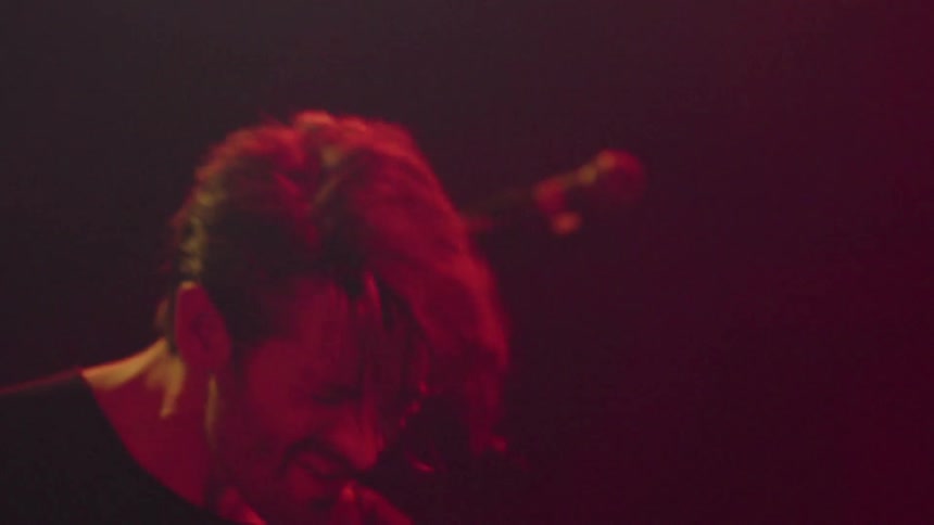 A band is performing on stage and getting into the music