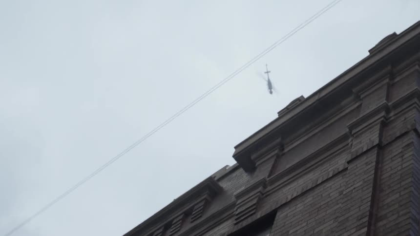 A helicopter is flying over a building