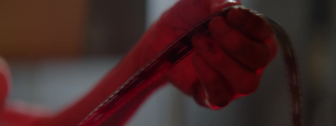 A woman develops film in a dark room