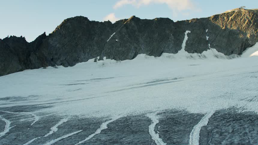 Ice covered mountain slopes up to a rocky mountain peak
