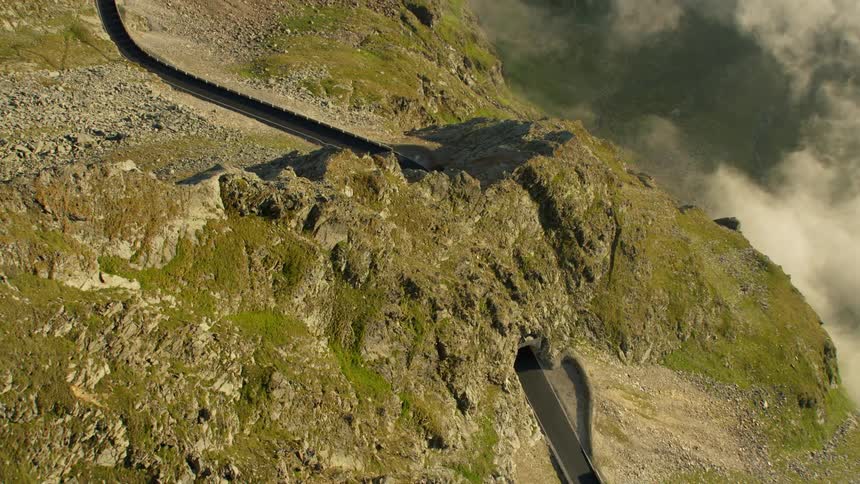 The road leads under the mountain and around below