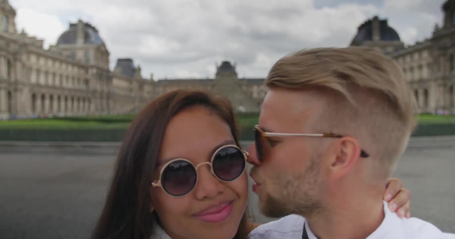 A couple smiling and kissing for the camera