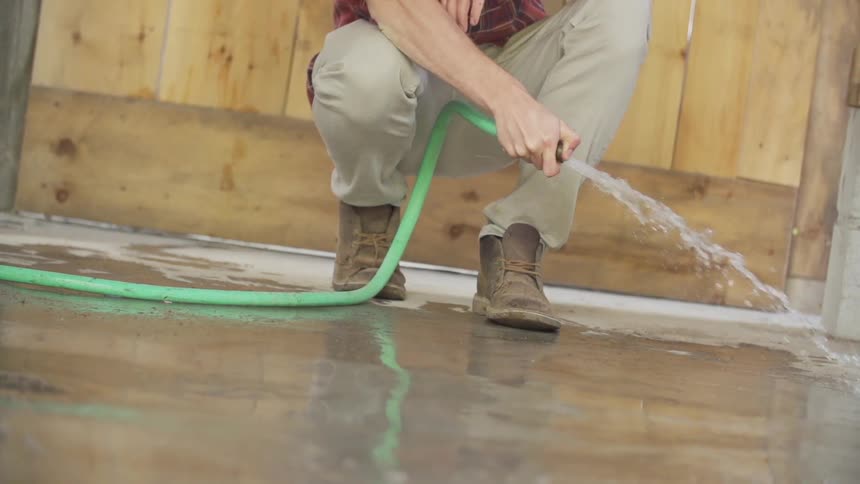 A man is spraying a water hose