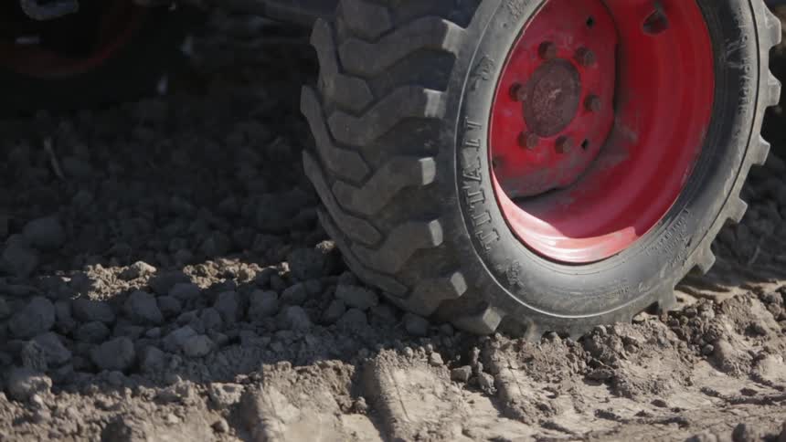 Close view of a tractor wheel crushing the ground beneath it