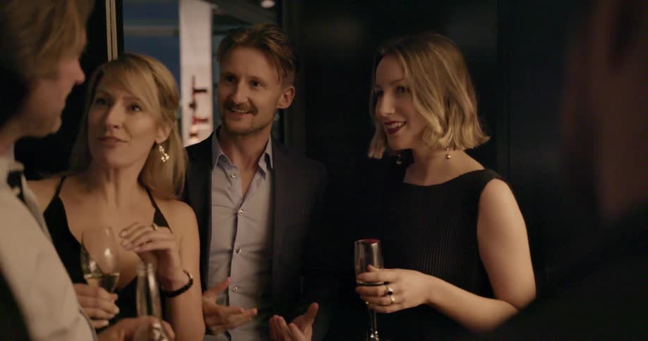 Men and women stand around talking