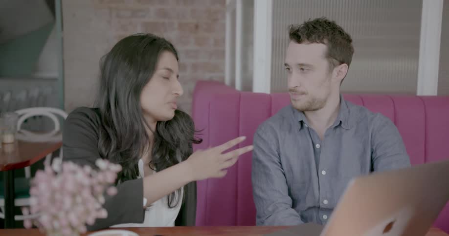A man and woman have a conversation in a diner