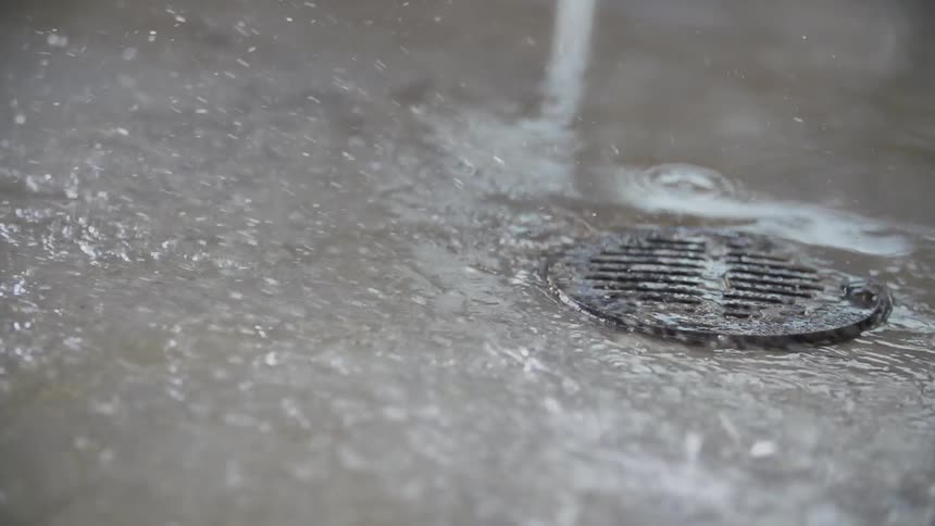 Water spraying on the ground towards a drain