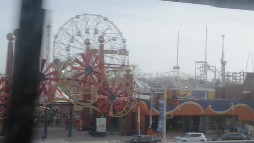 A carnival is being passed by something riding a train