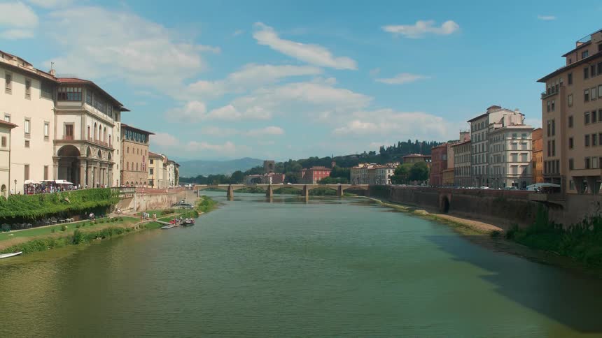 Cars drive across a river bridge connecting two areas with buildings