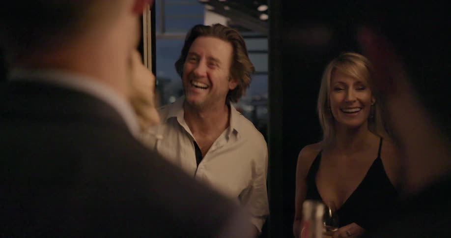 Men and woman stand around talking and laughing
