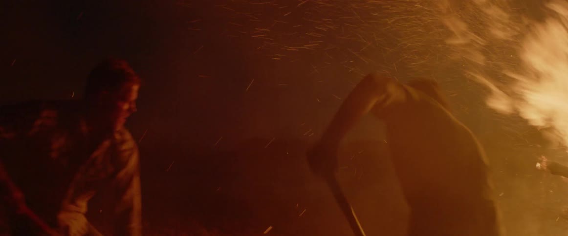 Men dig furiously near a large fire