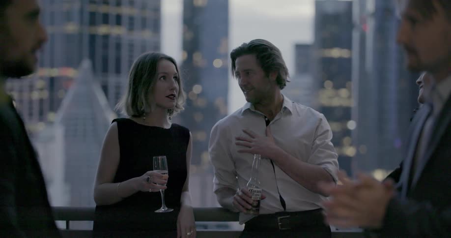 Man and woman drink champagne while talking at a party