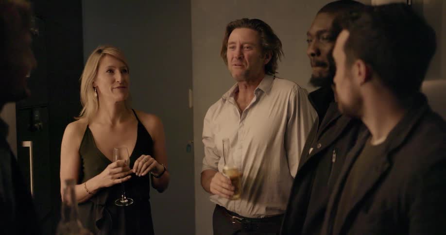 A group of people have a conversation at a party