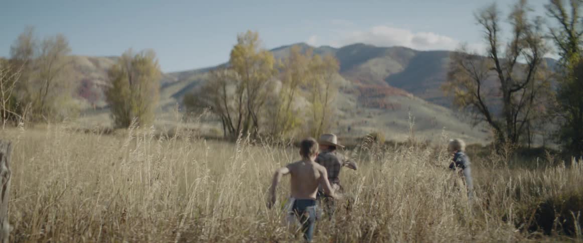 Children run playfully through a field