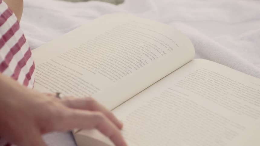 Woman reads a book on a beach