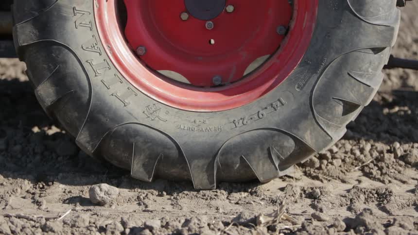 Close up view of tires rolling over a dirt field