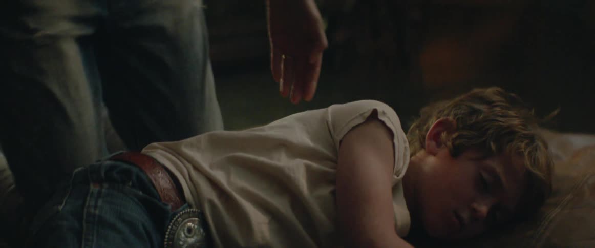 A quiet nighttime moment as a child is carried from the living room to bed