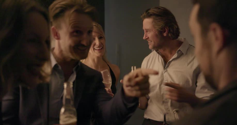 People laugh and have drinks at a party