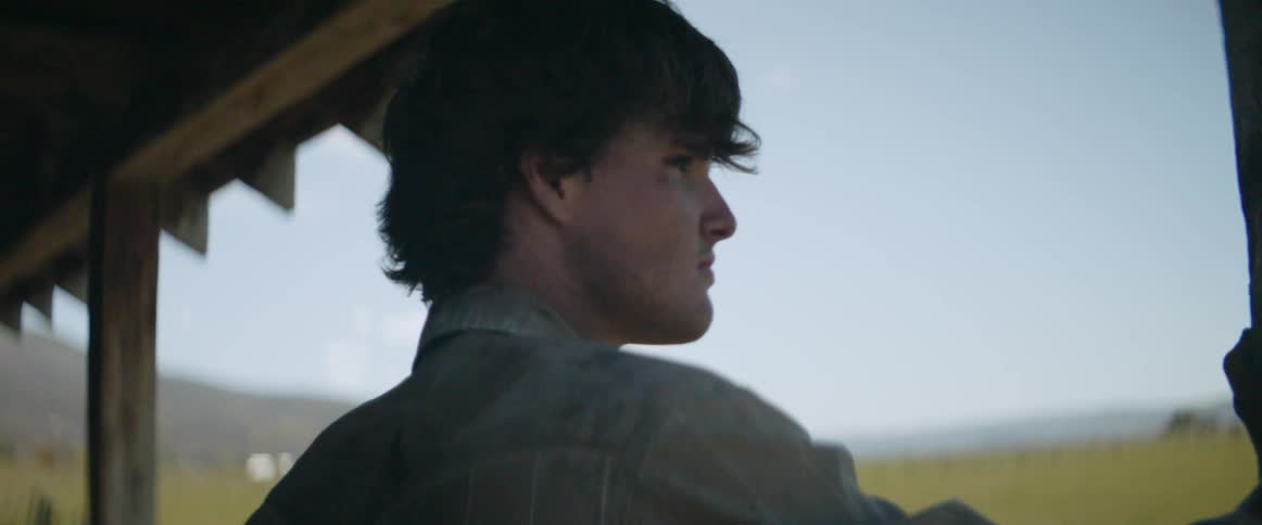A man looks out over a horizon from his porch