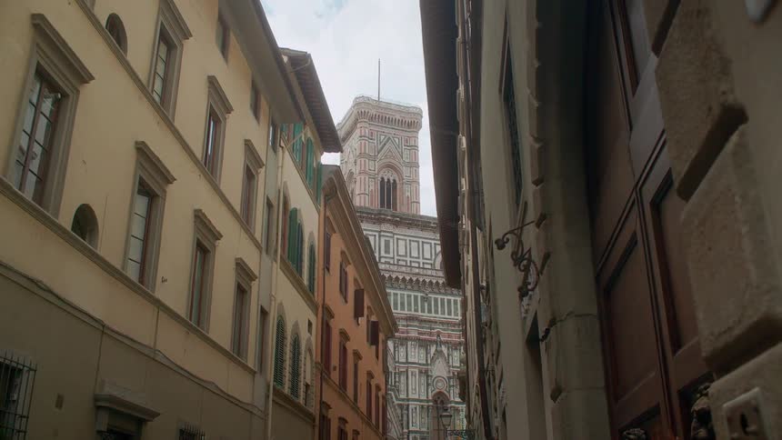 The tall buildings have many windows on a cloudy day