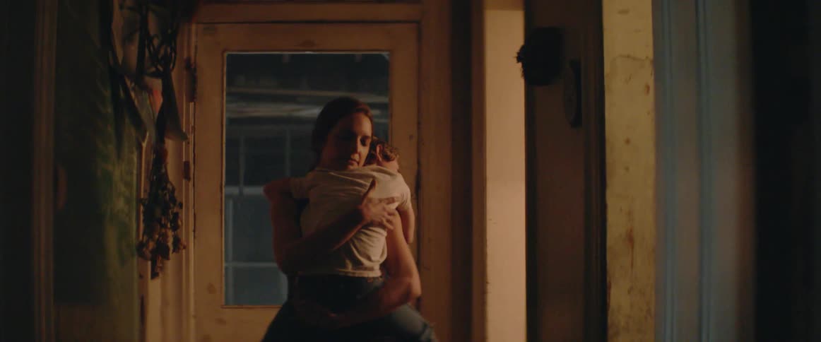 Mother Carries Her Sleeping Son Through a Quiet Home at Night