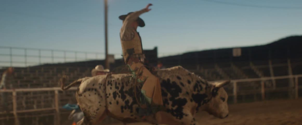 Cowboy rides a bull in a rodeo arena