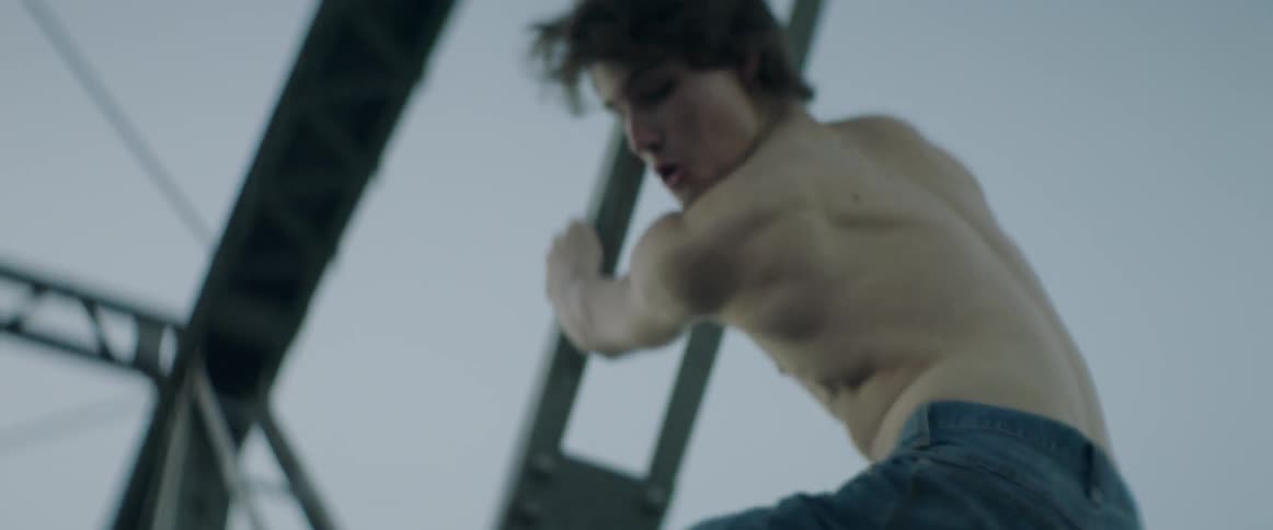 Two young men climb a bridge at dawn, chasing freedom and adventure