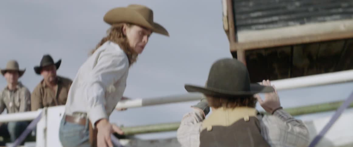 A cowboy runs towards the fence in a rodeo ring
