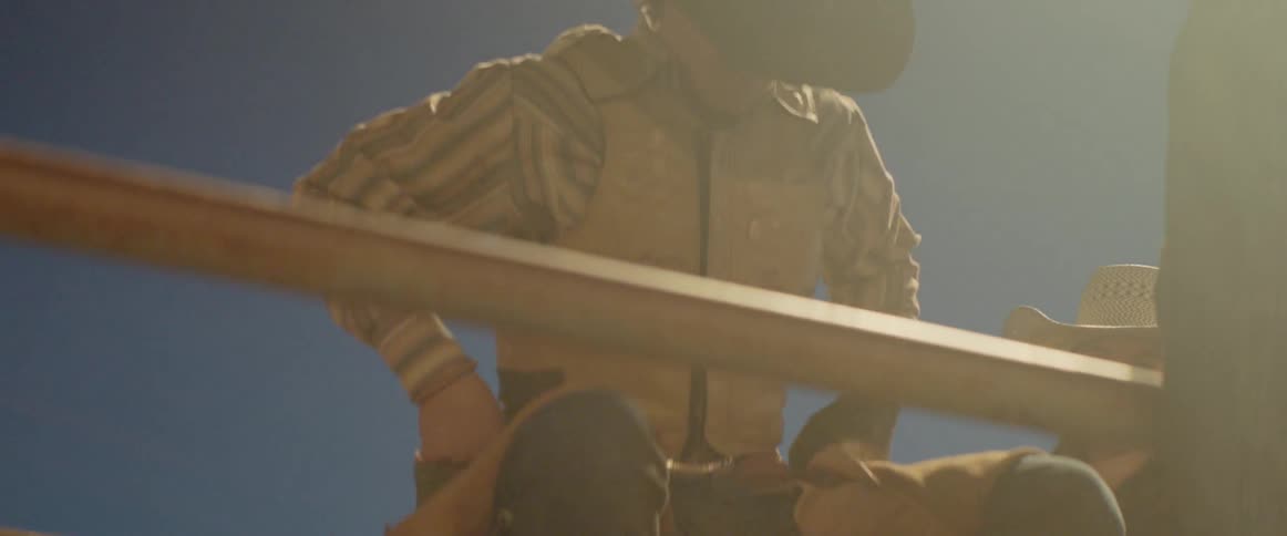 A rodeo rider jumps off the gate onto the bull