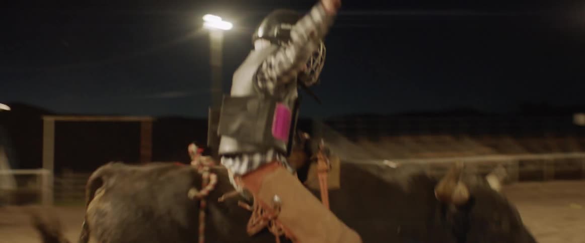 Man rides a bull in an arena