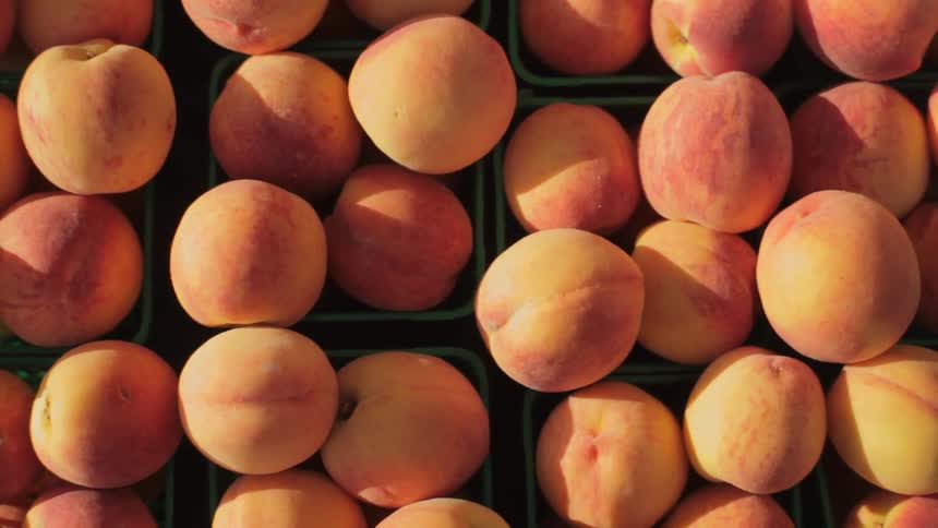 Close up of many peaches in containers