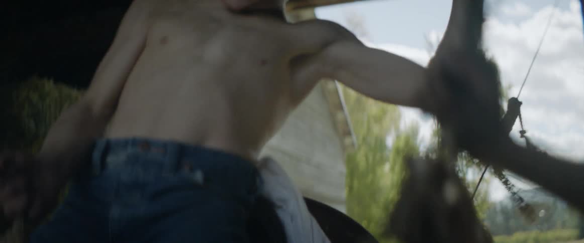 A boy rides a mechanical bull in an old barn