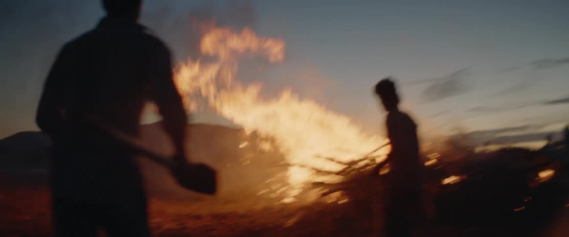 Two men frantically run to extinguish a fire