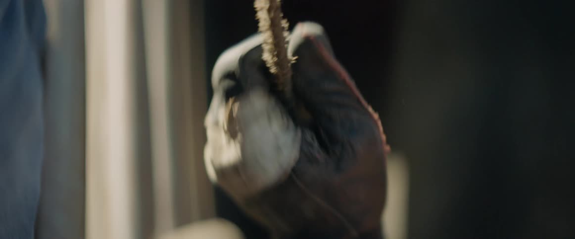 A man pulls on a rope to tighten it while wearing gloves