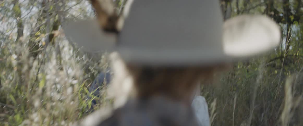 Boys walk through tall grass in a rural area