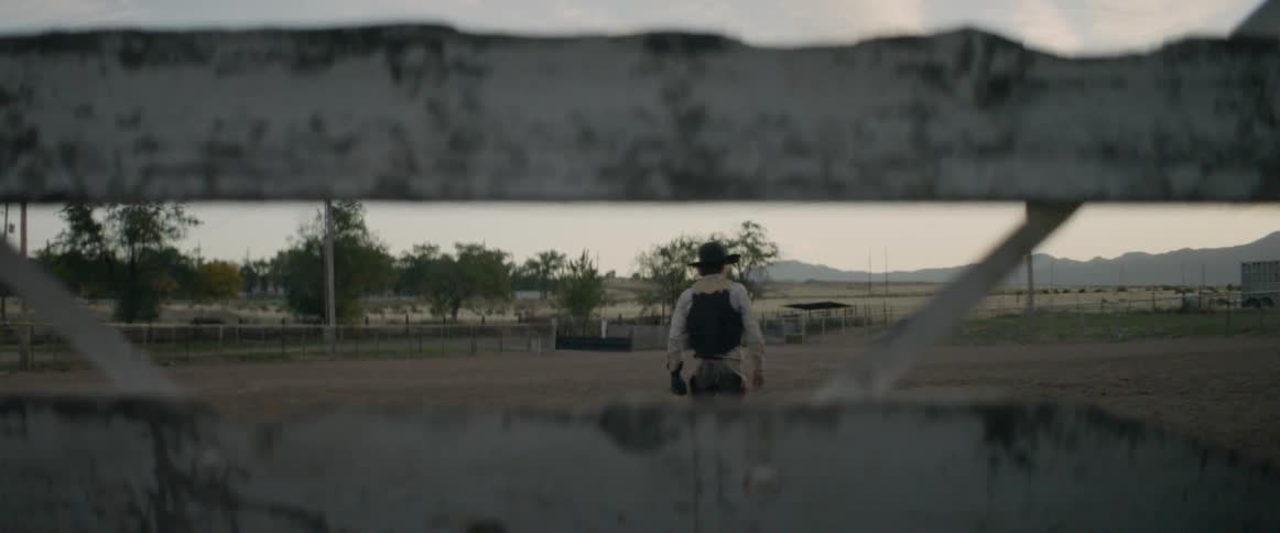 A bull rider walks through the arena