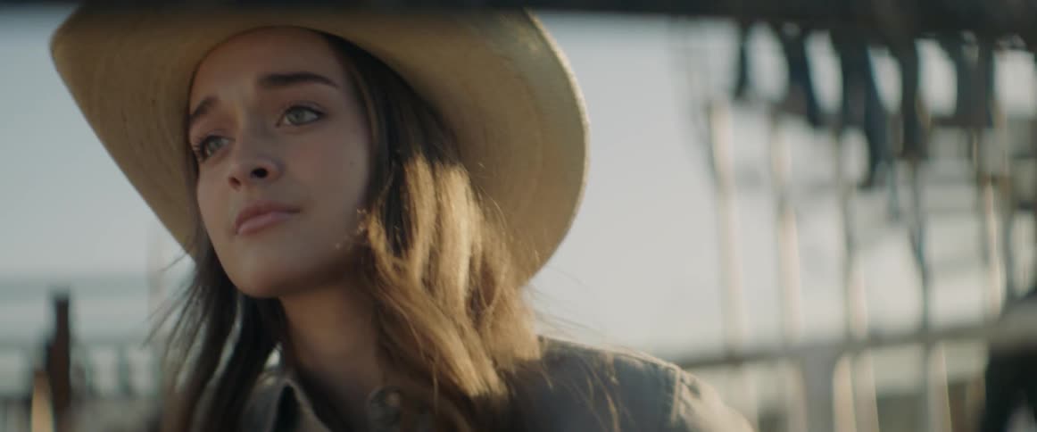 A girl in a cowboy hat is looking at something off camera