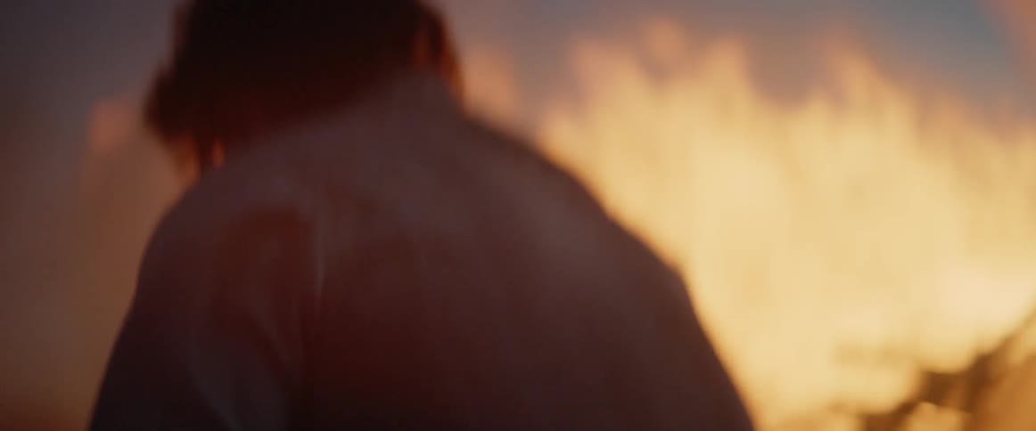A man digs at sunset trying to put out a fire