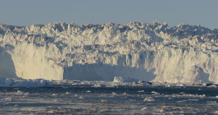 A huge iceberg is being filmed from a passing ship