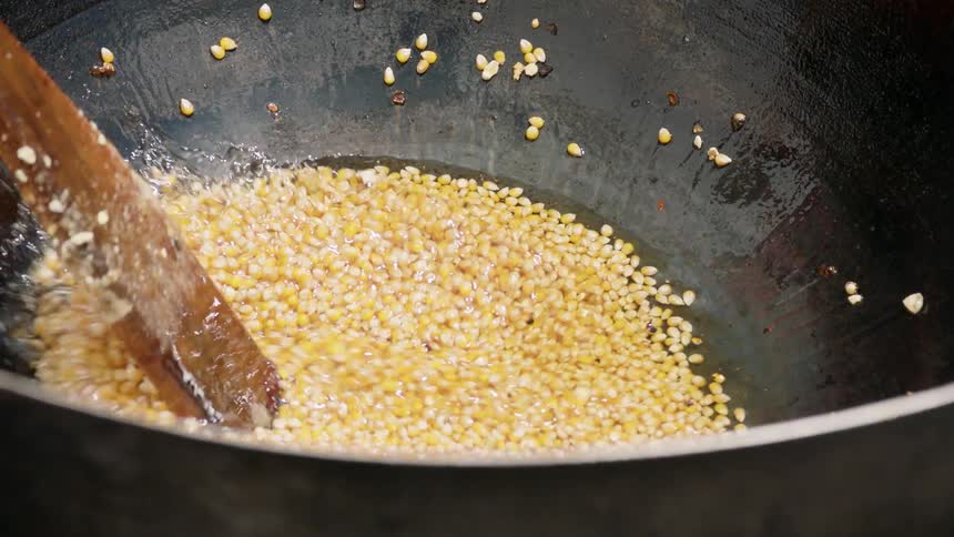 A man is making kettle corn in a large pot