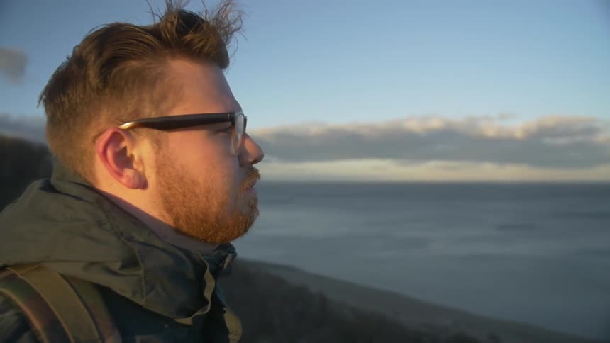 Man looking out over the water on a clear day