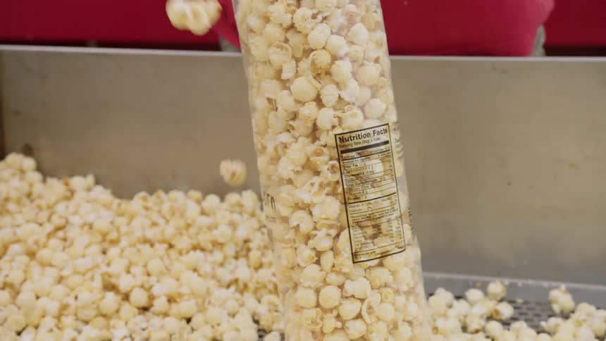 Man is scooping popcorn into a bag at fair