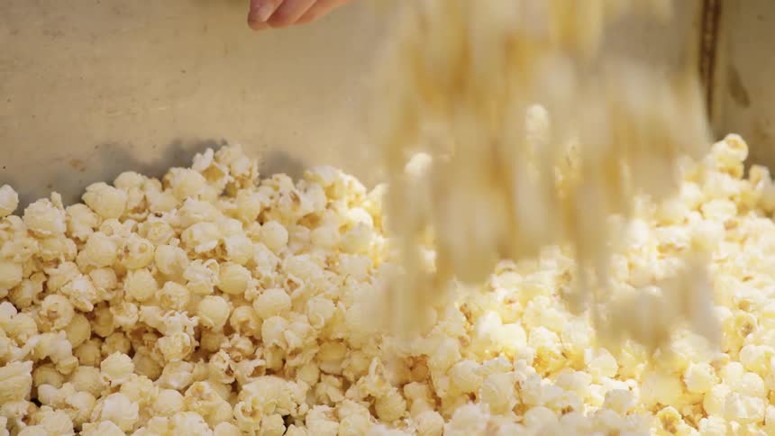 Person scoops popcorn out of a large kettle