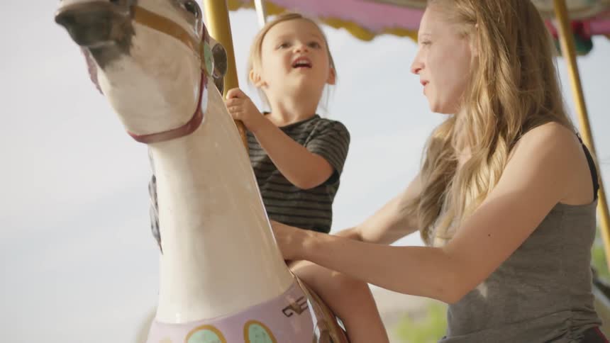 Woman and child ride on a carousel